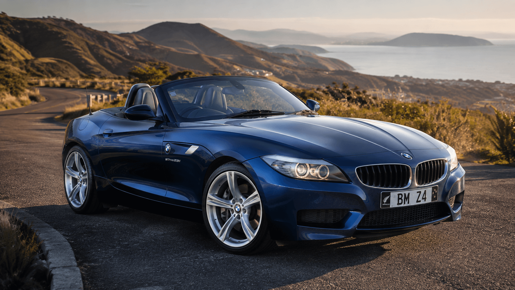 Blue BMW Z4 roadster on a scenic New Zealand road